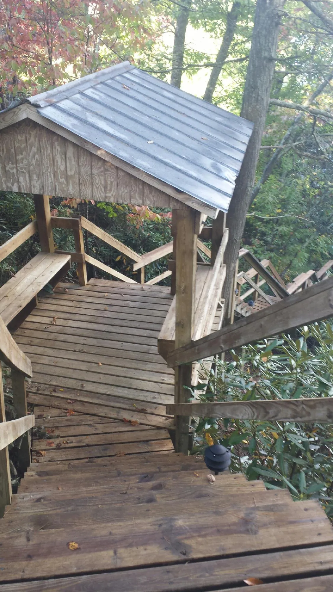 Metal roofed shelter over wooden steps on a wooded walkway — Skylight Repair & Installation work by our crew in Provo