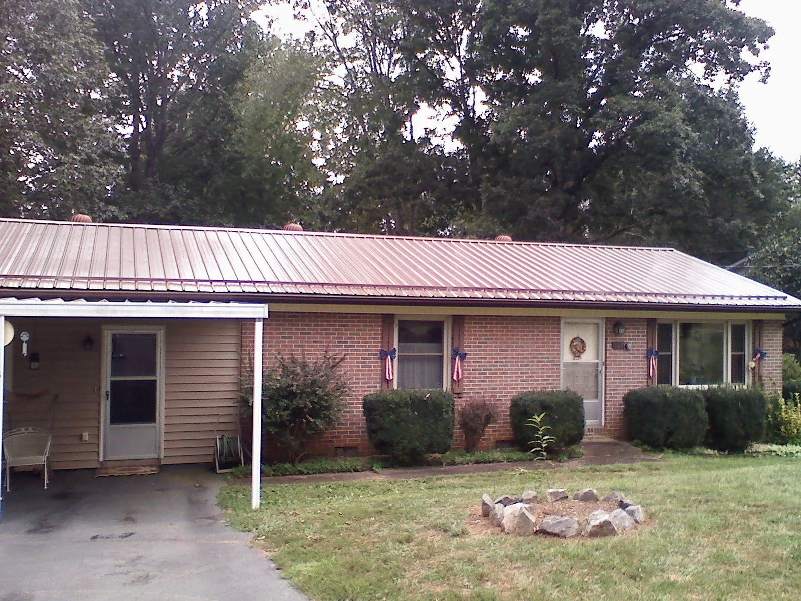 Bronze metal roof and carport on a brick ranch home — Roof Repair work by our crew in Provo